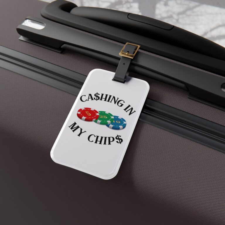 Ca$hing In My Chip$ acrylic luggage tag attached to a premium suitcase, featuring the signature poker chip logo and travel-inspired lifestyle branding.